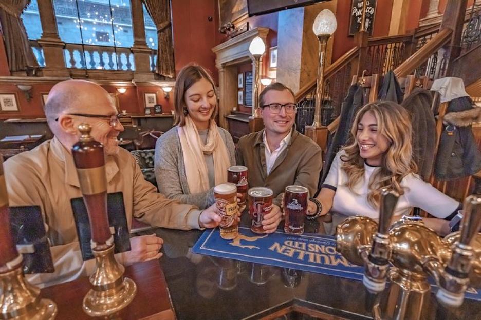 Four people enjoying drinks at a pub.