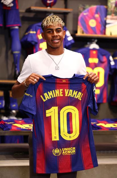 Lamine Yamal holding his FC Barcelona jersey.