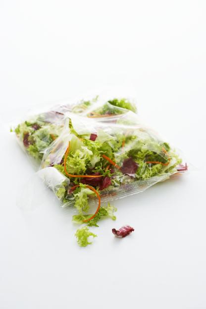 Mixed salad greens in a plastic bag.