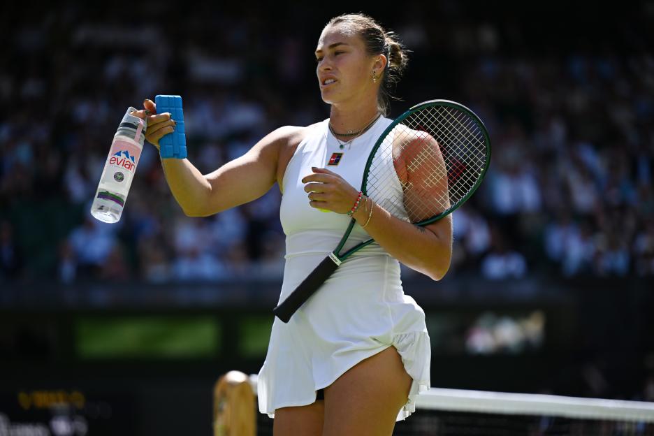 Aryna Sabalenka holding a water bottle and ice pack during a tennis match.