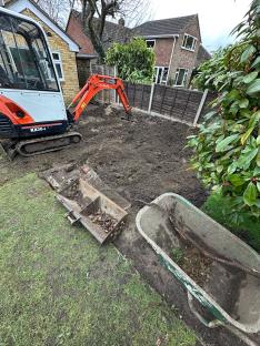 Mini excavator digging up a backyard for a pool.