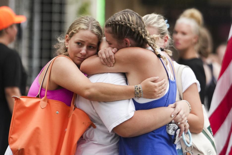 Campers embrace after reuniting with their families following heavy rainfall.