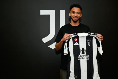 Lloyd Kelly holding a Juventus jersey.