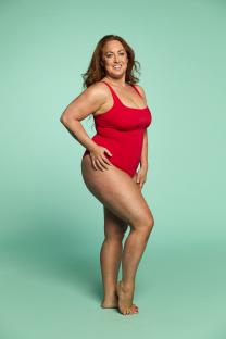 Woman in red swimsuit against a teal background.