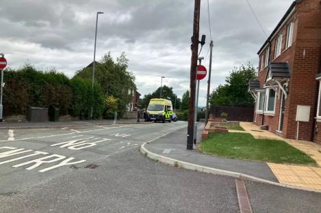 Ambulance parked on residential street near police officers.