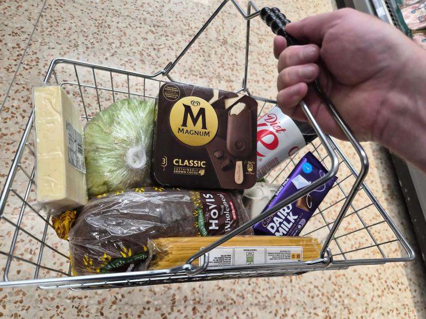 Shopping basket with groceries: cheese, lettuce, Magnum ice cream, bread, pasta, Diet Coke, and Dairy Milk chocolate.