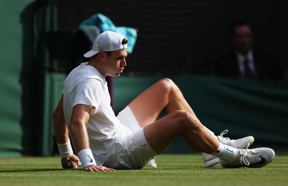 Jack Draper sitting on a tennis court.