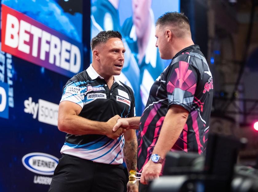 Two darts players shaking hands.