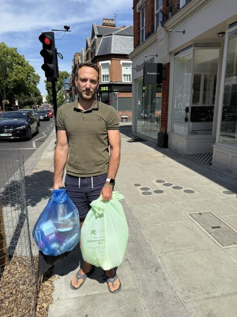 Man holding garbage bags and receiving a fine.