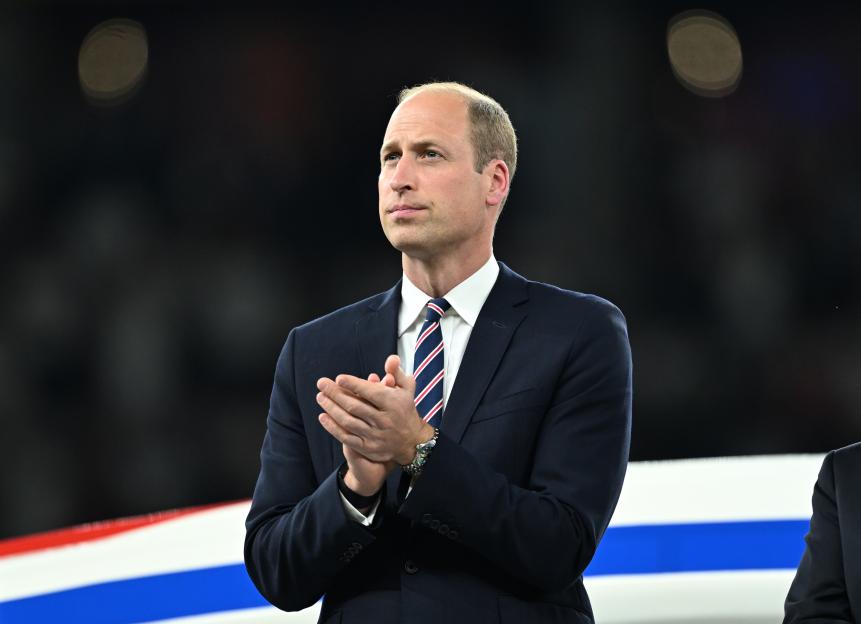 Prince William applauding at a sporting event.