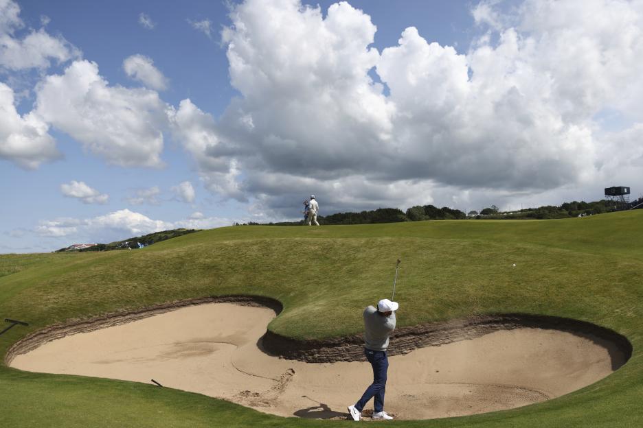 Scottie Scheffler playing golf from a bunker.