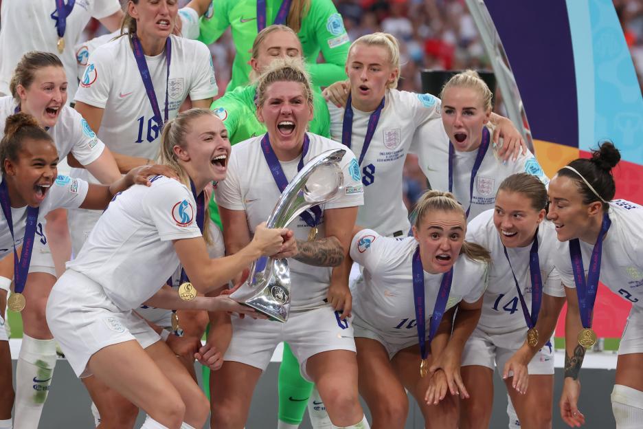 England's women's soccer team celebrates their victory, holding the trophy.