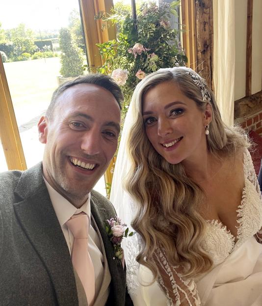 Newlywed couple smiling for a selfie.