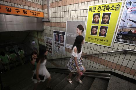 Plastic surgery advertisements on a subway staircase in Seoul.