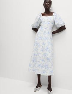 Model wearing a white floral midi dress.