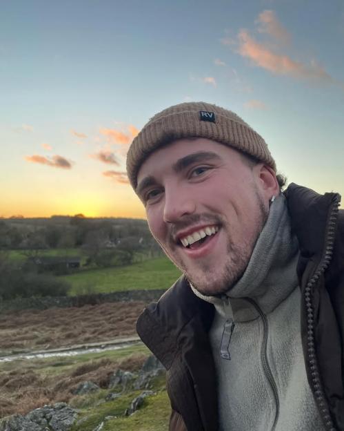 Man smiling at sunset.