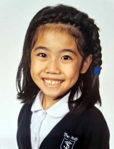 Portrait of a smiling girl in a school uniform.