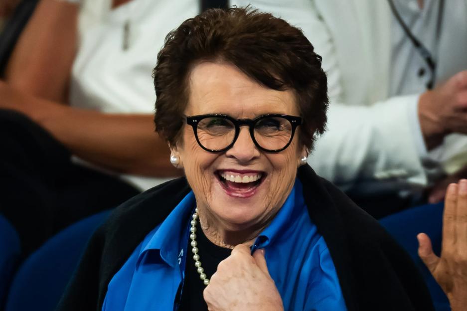 a woman wearing glasses and a blue shirt is smiling