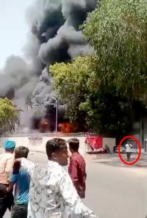 Footage of a man calmly walking away from a large fire.