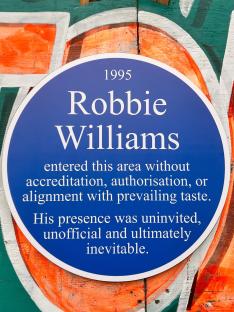 Blue plaque commemorating Robbie Williams' uninvited 1995 presence.