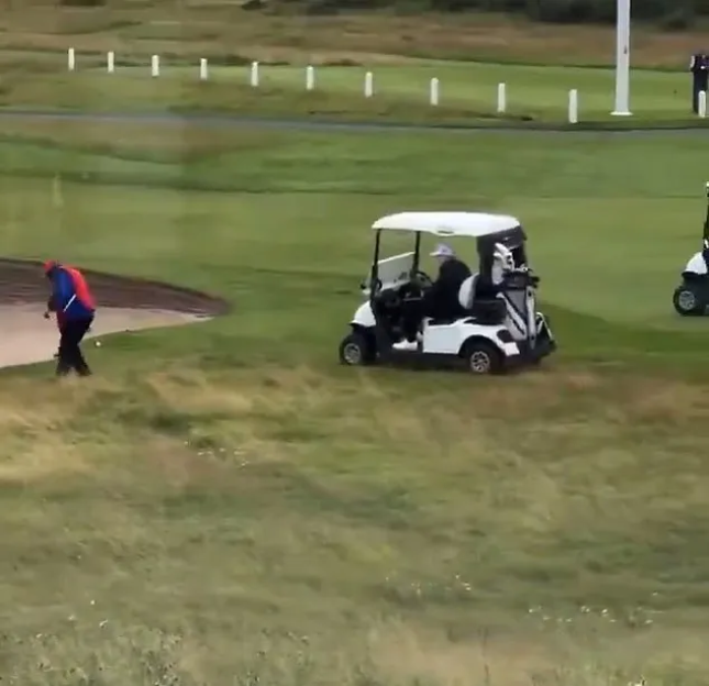 Golfer and golf carts on a course.