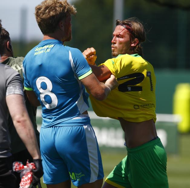 Two soccer players with head injuries clashing during a match.