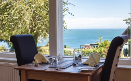 Table for two set by a window overlooking the ocean.