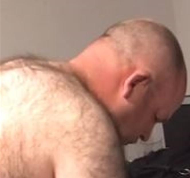 Hairy back of a man bending over.