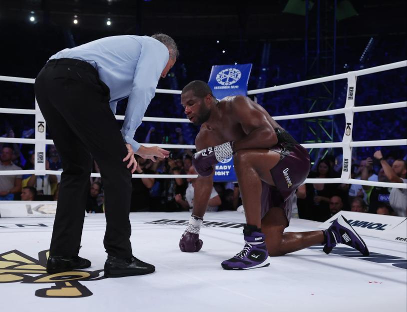 Referee attending to a downed boxer.