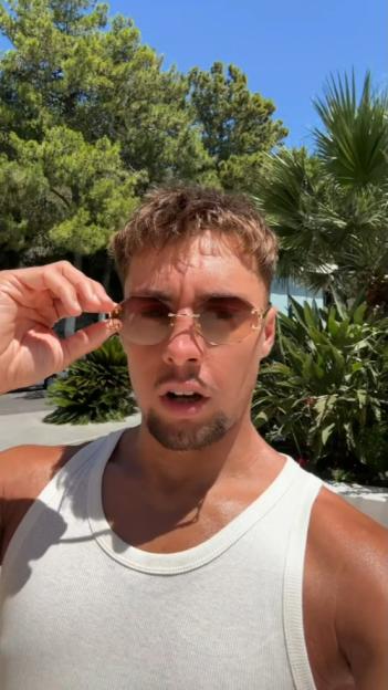 Frankie Davey, Love Island star, holding sunglasses.