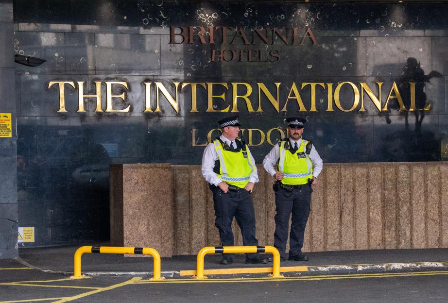 Two police officers standing outside The Britannia International Hotel in London.