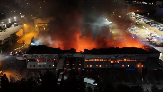 Aerial view of a large building engulfed in flames.