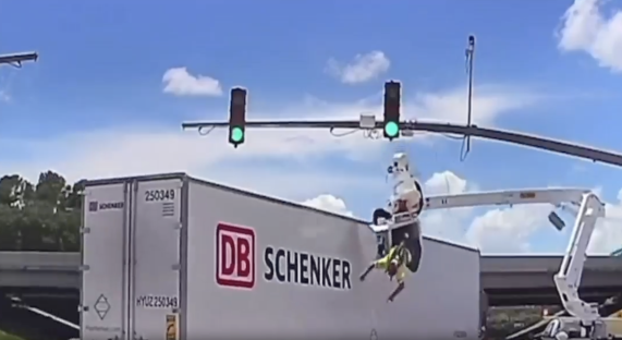 Person falling from a bucket truck onto a DB Schenker trailer.