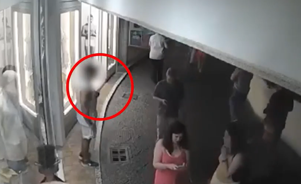 Security camera footage of a person in a crowd.