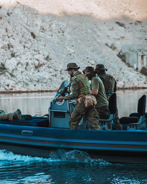 Soldiers in a rigid-hulled inflatable boat.