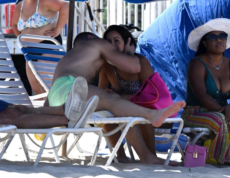 Conor McGregor kissing a woman on a beach.