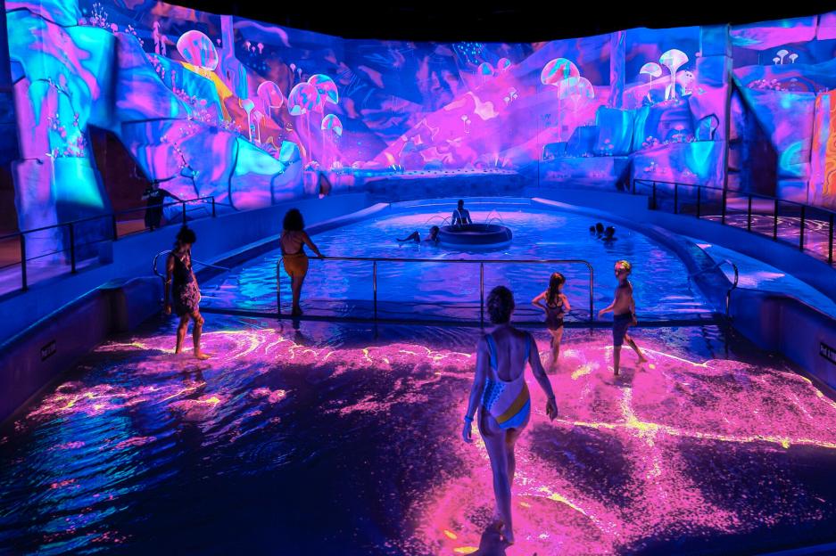 People enjoying a neon-lit water park.