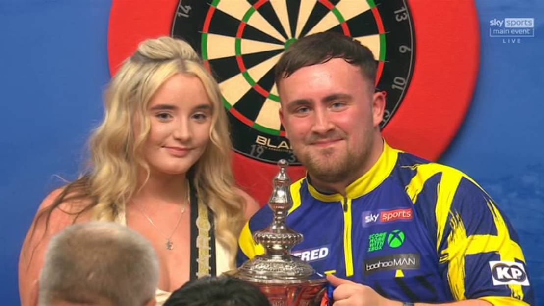 Man and woman holding a darts trophy.
