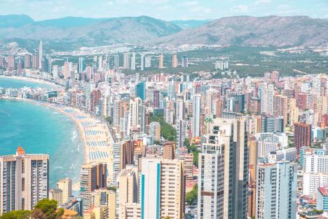 Aerial view of Benidorm, Spain, showing the city's high-rise buildings, beach, and coastline.