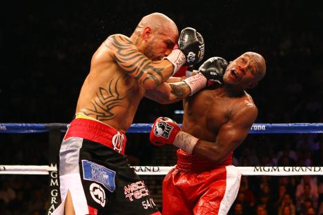 Miguel Cotto landing a left punch on Floyd Mayweather Jr. during a boxing match.