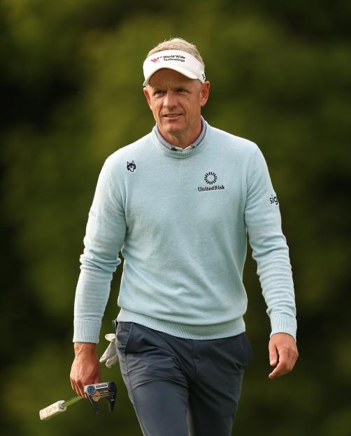 Luke Donald walking on a golf course.