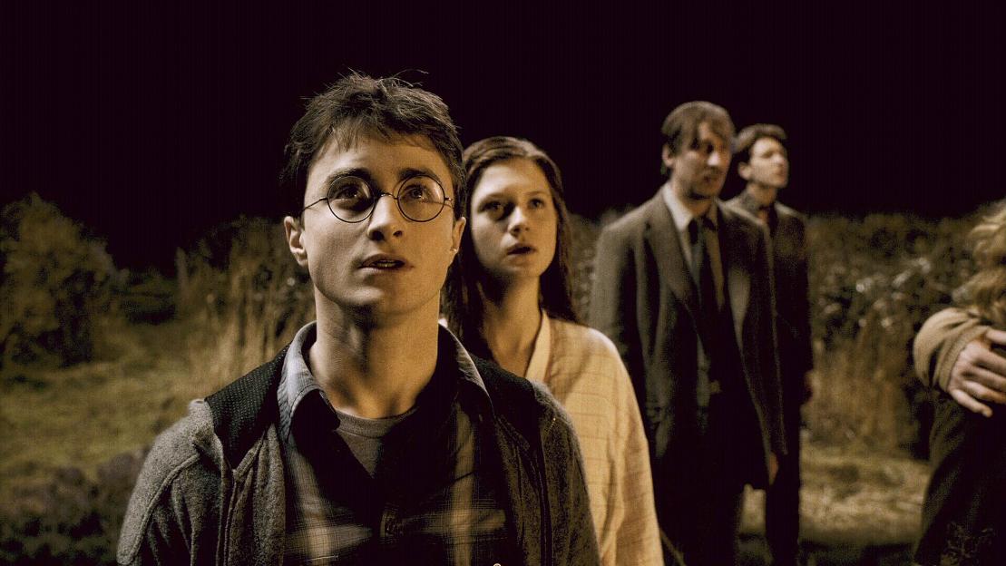 Daniel Radcliffe as Harry Potter with Ginny Weasley, Remus Lupin, and George Weasley.