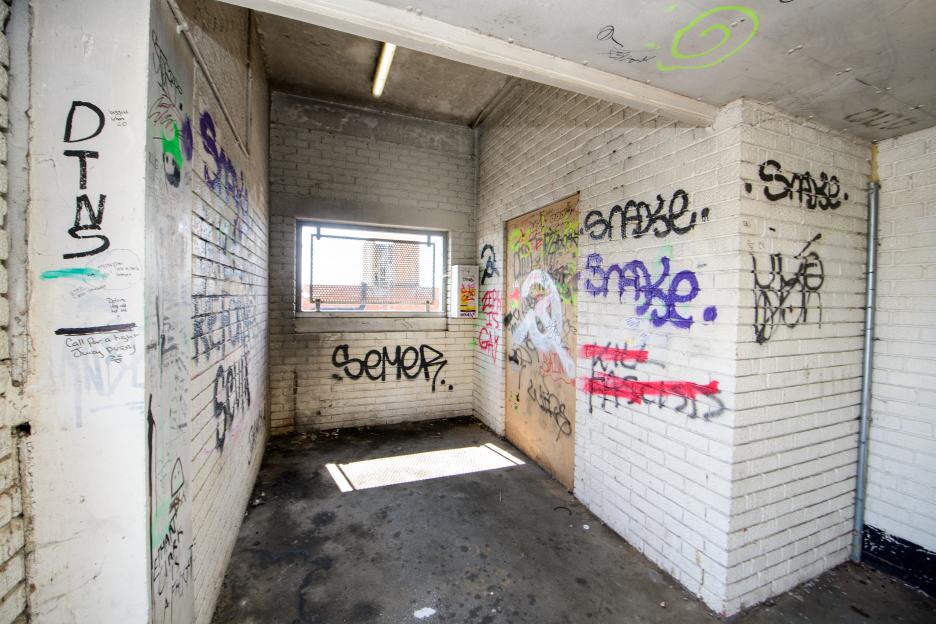 Graffiti-covered brick interior of a multi-story car park.