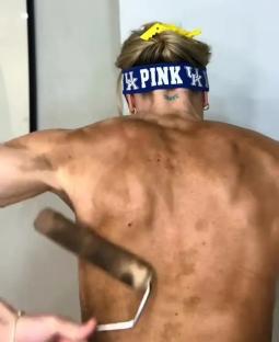 Person applying self-tanner to their back.