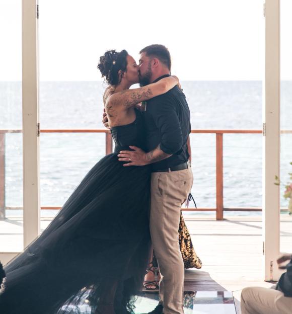 A bride and groom kissing at their wedding ceremony.