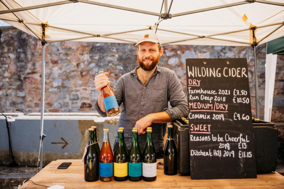 Man selling Wilding Cider at a market stall.