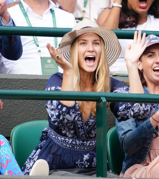 Louise Jacobi cheering at a tennis match.