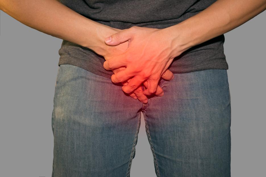 Person holding their groin in pain.