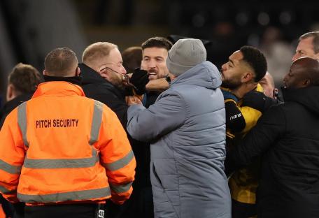 WOLVERHAMPTON, ENGLAND - DECEMBER 14: Matheus Cunha of Wolverhampton Wanderers grabs the face and pulls the glasses off an Ipswich Town staff member after the Premier League match between Wolverhampton Wanderers FC and Ipswich Town FC at Molineux on December 14, 2024 in Wolverhampton, England. (Photo by Catherine Ivill - AMA/Getty Images)