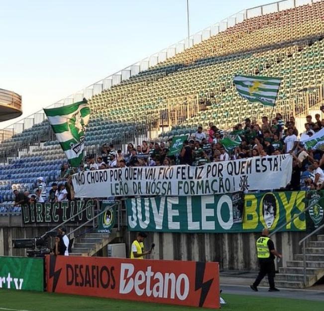 Sporting fans display banners at a stadium.